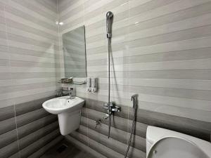 een badkamer met een wastafel, een toilet en een douche bij OYO 1204 Hoang Linh Hotel in Da Lat