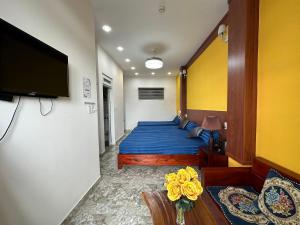 een slaapkamer met een bed met blauwe lakens en een televisie bij OYO 1204 Hoang Linh Hotel in Da Lat