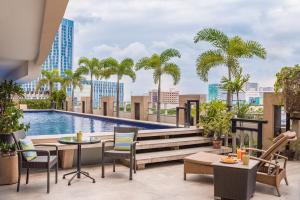 een patio met een zwembad en palmbomen bij Vivere Hotel and Resorts in Manilla