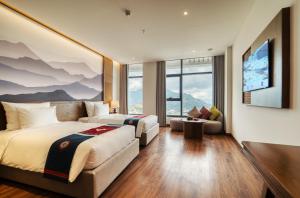a hotel room with two beds and a flat screen tv at Lady Hill Sapa Resort in Sa Pa