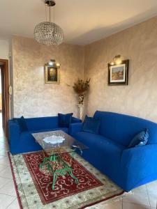um sofá azul numa sala de estar com uma mesa em La Casa dell'Artista em Battifolle