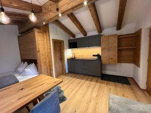 a kitchen with wooden cabinets and a table in a room at Chalet Bergliebe in Bad Hofgastein