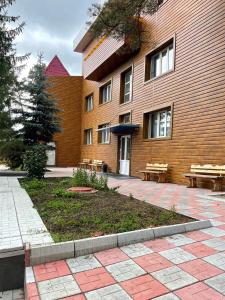 a building with benches in front of a building at Hotel Palladium in Shchūchīnsk