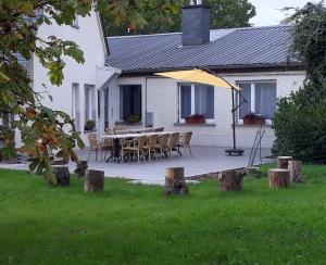 una mesa y sillas frente a una casa blanca en Villa Franzen, en Derenbach