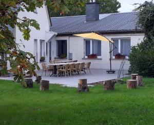 a table and chairs in front of a white house at Villa Franzen in Derenbach