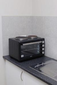 a black microwave sitting on a counter in a kitchen at J$T Urban Bliss in Newton Park