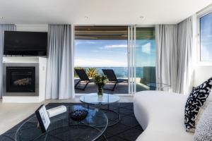 a living room with a white couch and a fireplace at 26OnFirst - UPS, Sea Views and Personalised Services in Cape Town