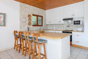 a kitchen with a wooden counter top and wooden stools at San Lameer Villa 10312 - 3 Bedroom Standard - 6 pax - San Lameer Rental Agency in Southbroom