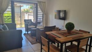 a living room with a dining room table and chairs at Self Catering. walking distance to beach. in Uvongo Beach