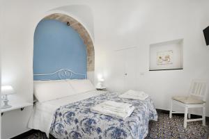 ラグーザにあるIl Quartino Di Palazzo Maggioreのベッドルーム(青と白のベッド1台、椅子付)