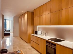 a kitchen with wooden cabinets and a microwave at Mercado Central Apartments in Valencia
