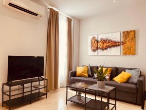 sala de estar con sofá y TV de pantalla plana en Mercado Central Apartments en Valencia