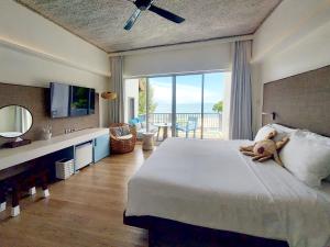 七岩Veranda Resort & Villas Hua Hin Cha Am的一间带大床的卧室，可欣赏海景