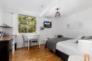 1 dormitorio con 1 cama y 1 mesa con sillas en Rosella's On Springbrook en Springbrook