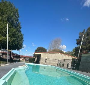 una piscina de agua azul frente a una valla en Murgon Motor Inn, en Murgon