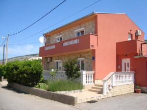 a red brick house with a white fence in front of it at Apartment & Apartment Studio Deželjin in Senj