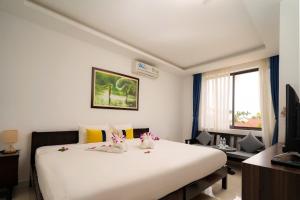 a bedroom with a large white bed with flowers on it at 5 Coconut Villa in Hoi An