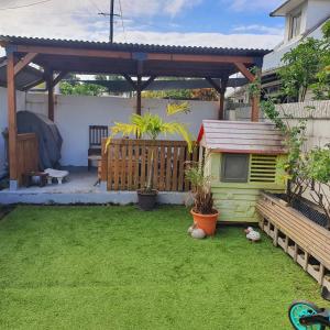 a small backyard with a gazebo and a yard at Appart Angel in Saint-Benoît
