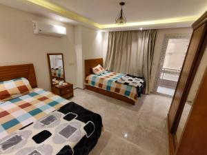 a bedroom with two beds and a mirror at شقة مستوى فندقى المهندسين للعائلات فقط in Cairo