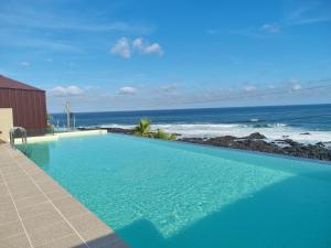 a swimming pool with a view of the ocean at The Villas Ocean for Family in Seogwipo