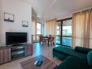 a living room with a couch and a tv at Bendida Village in Pavel Banya