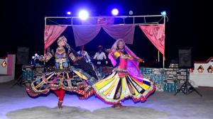 two women are performing a dance on a stage at Aroma Desert Safari Camp in Sām