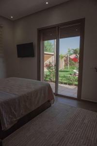 a bedroom with a bed and a sliding glass door at Villa Treasure of Marrakech in Marrakech