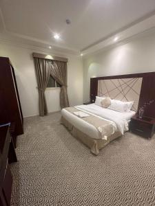 a bedroom with a large bed and a television at Al Joon Aparthotel in Riyadh