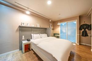 a bedroom with a large white bed and a window at HOTEL STAY AYANA DAEJEON in Daejeon