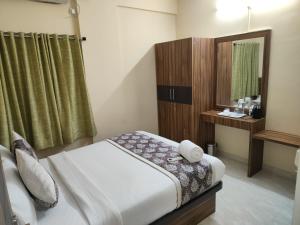 Dormitorio pequeño con cama y espejo en Hotel Bulande Comforts-1 Bedroom Flat, en Bangalore