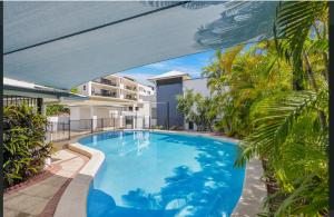 a large blue swimming pool with a bridge over it at Marina Views On Melton | 107/3 Melton Terrace Townsville in Townsville