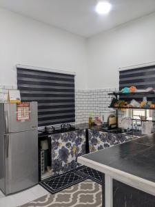 uma cozinha com um frigorífico e uma mesa em Homestay kg tanjung sik em Sik