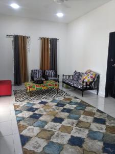 uma sala de estar com dois sofás e um tapete em Homestay kg tanjung sik em Sik