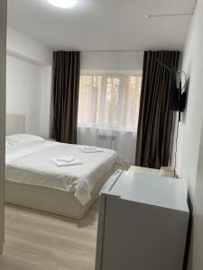 biała sypialnia z łóżkiem i oknem w obiekcie Hotel Palladium w mieście Szczuczyńsk