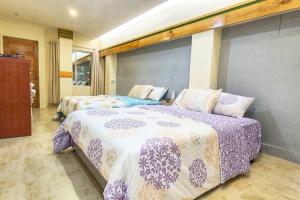 a bedroom with two beds with purple and white sheets at 2 Houses w/ parking for best guest in Iloilo City