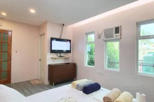 a bedroom with a tv on the wall and a couch at 2 Houses w/ parking for best guest in Iloilo City