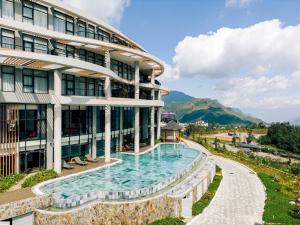 a hotel with a swimming pool in front of a building at Lady Hill Sapa Resort in Sa Pa