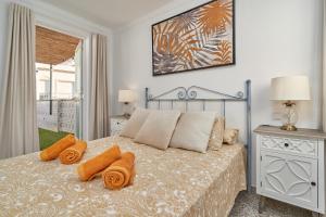 1 dormitorio con 1 cama con almohadas de color naranja en Soleada Casa en Nerja, en Nerja