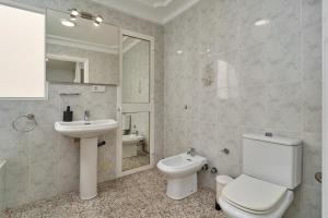 Un baño blanco con inodoro y lavabo. en Soleada Casa en Nerja, en Nerja 17 fotos más