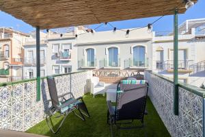 Un balcón con sillas y vista a un edificio. en Soleada Casa en Nerja, en Nerja