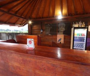 a wooden bar in a restaurant with a statue at OYO 93121 Abi Bungalow & Hostel in Pawenang