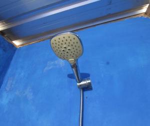 a shower head hanging on a blue wall at OYO 93121 Abi Bungalow & Hostel in Pawenang