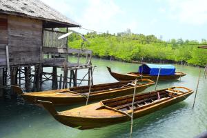 drie boten zijn vastgebonden aan een dok in het water bij Kelong Bintan in Telukbakau