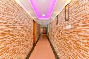 Trippapur的住宿－OYO Flagship Uthradam Towers，一条带紫色天花板和砖墙的走廊