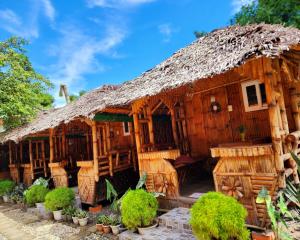 a wooden house with a thatched roof at Uno Dus Tourist Inn in Itaytay