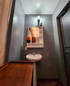 a bathroom with a sink and a mirror at Uno Dus Tourist Inn in Itaytay