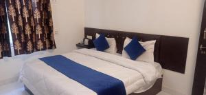 a bedroom with a bed with blue and white pillows at Ranthambhore Bagh Niwas in Sawāi Mādhopur +26 photos