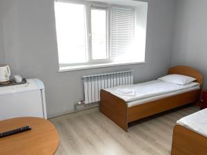 a small bedroom with a bed and a window at Hotel Palladium in Shchūchīnsk