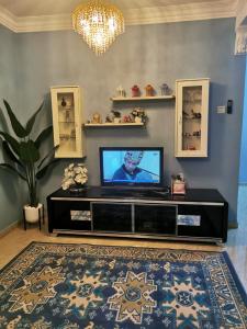 a living room with a flat screen tv on a entertainment center at Iwan Ila Homestay in Batang Kali