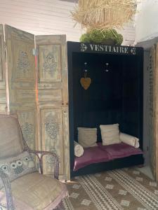 um quarto com um sofá, uma cadeira e uma porta em La Maison du Bonheur em Thiel-sur-Acolin
